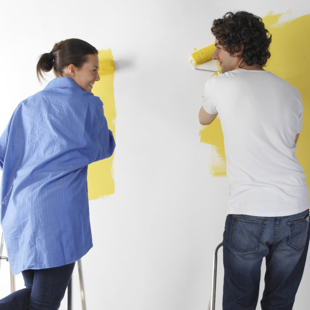 Man and woman painting a wall